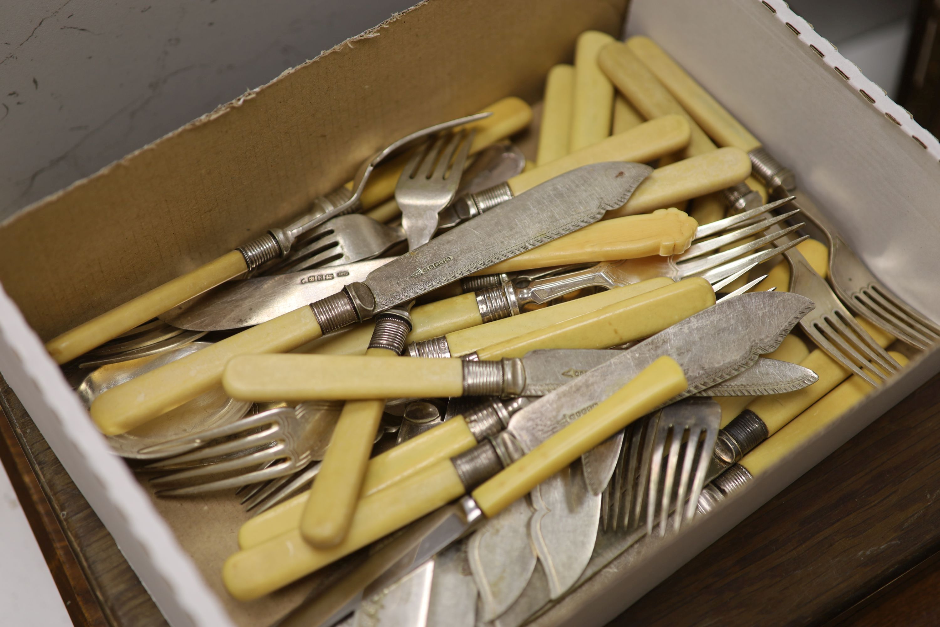 Three boxes of mixed fish eaters and flatware and two boxes of silver teaspoons and silver knives and forks.